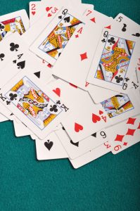 heap of playing cards on a green cloth background